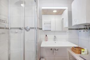 a white bathroom with a sink and a shower at Ferienwohnung Krokus in Weiler-Simmerberg +34 photos