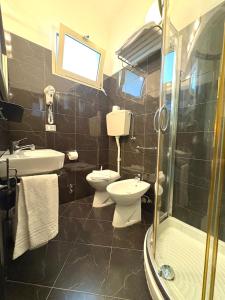 a bathroom with a toilet and a sink and a shower at Hotel San Carlo in Cesenatico +22 photos