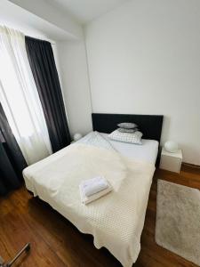 a bedroom with a bed with white sheets and a window at City apartment with private parking in Nuremberg