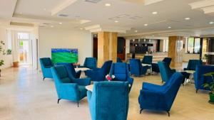 a waiting room with blue chairs and tables at Canyon Hills Hotel in Yerevan