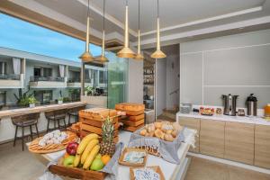a kitchen with a table with fruits and vegetables on it at Pefki Deluxe Residences - Adults Only 16plus in Pefkochori
