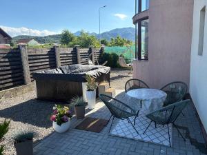 a patio with a table and chairs and a table and a table and chairs at MIK Chalet in Săcele