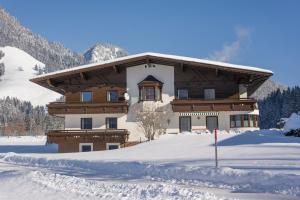 ein Chalet in den Bergen im Schnee in der Unterkunft Appartementhaus Montana KG in Walchsee