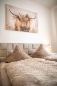 a bed with a picture of a bull on the wall at FeWo LUNA in Riesa
