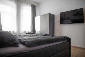 a bedroom with a bed with a television on the wall at FeWo LUNA in Riesa
