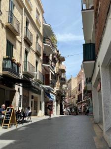 a woman walking down a street with buildings at Piso Bonaire in Sitges