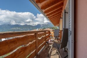 a balcony with chairs and a view of mountains at Agritur Fiordaliso in Predaia