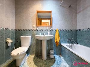 a bathroom with a toilet and a sink and a tub at The Skyline in Grao de Castellón