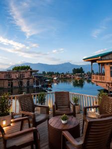 a balcony with chairs and tables and a view of a river at Dilnaaz Group Of Houseboats in Srinagar