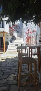 a table and chairs sitting under a tree at VRACHOS HOUSE "In the heart of Skopelos Town" in Skopelos Town
