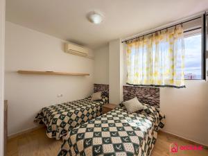 two beds in a small room with a window at The Skyline in Grao de Castellón