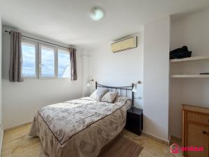 a white bedroom with a bed and a window at The Skyline in Grao de Castellón