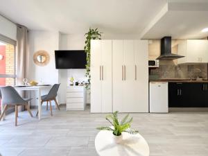 a kitchen with white cabinets and a table with a plant at Hercules Cozy Studio - City Center and Near Beach in Benalmádena