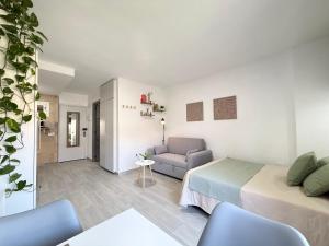 a white bedroom with a bed and a couch at Hercules Cozy Studio - City Center and Near Beach in Benalmádena