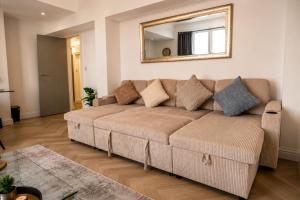 a living room with a couch and a mirror at Luxe By The Sea - Luxury in the Centre of Brighton - Aparthotel - 3 Beautiful Apartments - Penthouse Available in Brighton & Hove