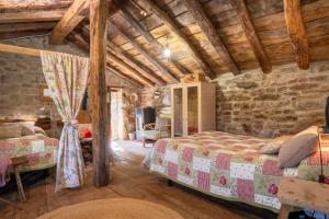 a bedroom with two beds and a stone wall at Vivienda pasiega LO LUCAS 1920 in San Roque de Ríomiera