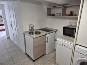 a small kitchen with a sink and a microwave at Studio Danna in Menton
