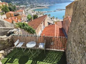 two chairs and a table on a balcony overlooking the water at Studio Danna in Menton