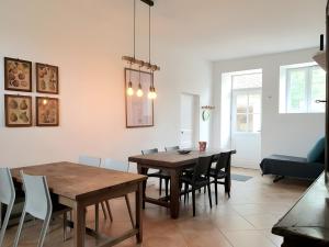 a dining room with a wooden table and chairs at Le gîte de Bresteau in Beillé