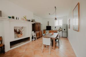 a kitchen with a table and a dining room at Le gîte de Bresteau in Beillé
