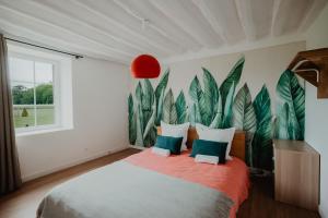 a bedroom with a large bed with green leaves painted on the wall at Le gîte de Bresteau in Beillé