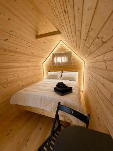a small room with a bed in a wooden ceiling at Bela Resort - Glamping in Motnik