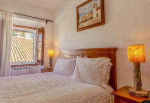 a bedroom with a bed with white pillows and a window at Dom Dinis Marvão in Marvão +183 photos