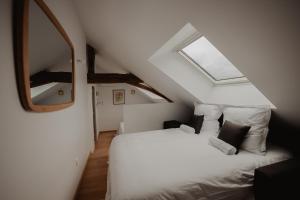 a attic bedroom with a bed and a mirror at L'annexe de Bresteau in Beillé