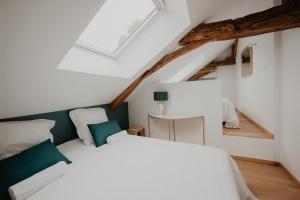 a bedroom with a white bed with green accents at L'annexe de Bresteau in Beillé