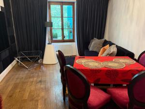 a living room with a red table and a couch at Appartement vue lac Montreux in Montreux