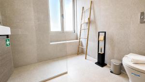 a bathroom with a ladder next to a toilet at Heritage Apartments in Câmara de Lobos