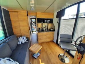 a living room with a couch and a kitchen at Domki pływające HouseBoat4U in Ruciane-Nida