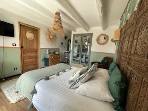 a bedroom with a large bed with pillows on it at Chez TROTRO in Saint-Pierre-de-Plesguen