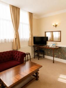 a living room with a red couch and a desk at The Lairgate in Beverley