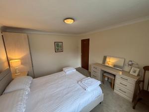a bedroom with a bed and a desk with a television at 1 Bedroom Chalet in West Runton