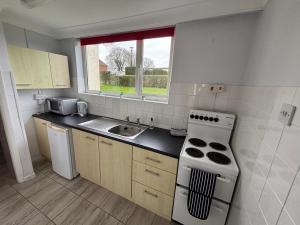 a kitchen with a stove and a sink and a window at 1 Bedroom Chalet in West Runton