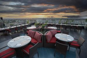 a restaurant with tables and chairs and a view of a city at Park Central Hotel in Ahmadnagar