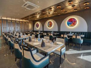 a dining room with tables and chairs and paintings on the walls at Park Central Hotel in Ahmadnagar