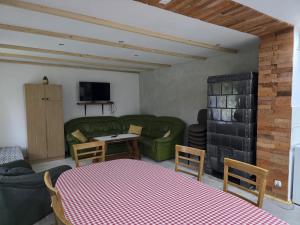 a living room with a green couch and a table at PRZYSTANEK nowEKOprzywno - Żółty Domek Pod Kasztanem in Barwice