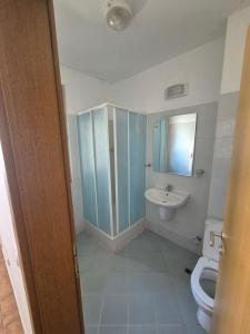 a bathroom with a toilet and a sink at Helios Beach Apart Garden in Pomorie