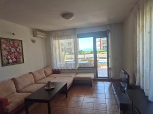 a living room with a couch and a table at Helios Beach Apart Garden in Pomorie