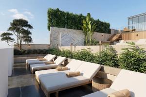 a row of white chaise lounges on a rooftop at Classyc Hotel Hang Buom in Hanoi