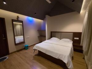 a bedroom with a large bed and a mirror at khopoli resort in Khopoli