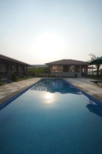 a swimming pool in front of a building at khopoli resort in Khopoli