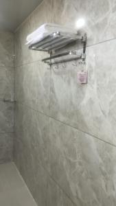 a bathroom with a tiled shower with a light on the wall at khopoli resort in Khopoli