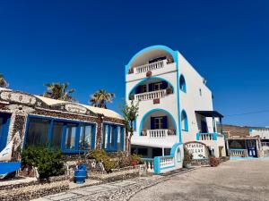 a blue and white building with a balcony at Stavros Beachfront Domes by Booking Kottas in Perivolos