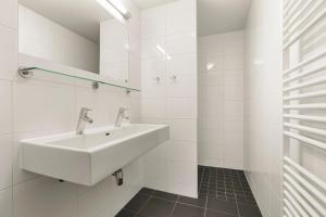 a white bathroom with a sink and a mirror at Landal Winterberg in Winterberg +68 photos