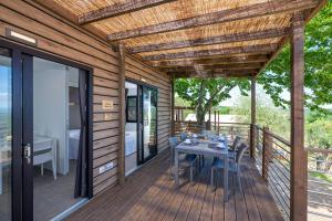 a wooden deck with a table and chairs on it at Etrusco Camping Village in Casiano