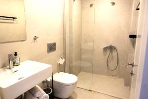 a bathroom with a shower and a toilet and a sink at Amber Butik Otel in Çeşme +19 photos