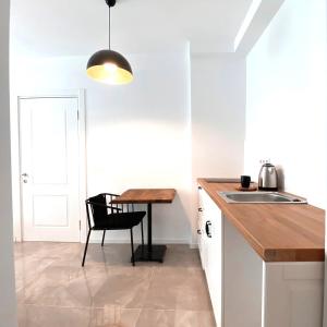 a kitchen with a table and a chair next to a sink at Amber Butik Otel in Çeşme